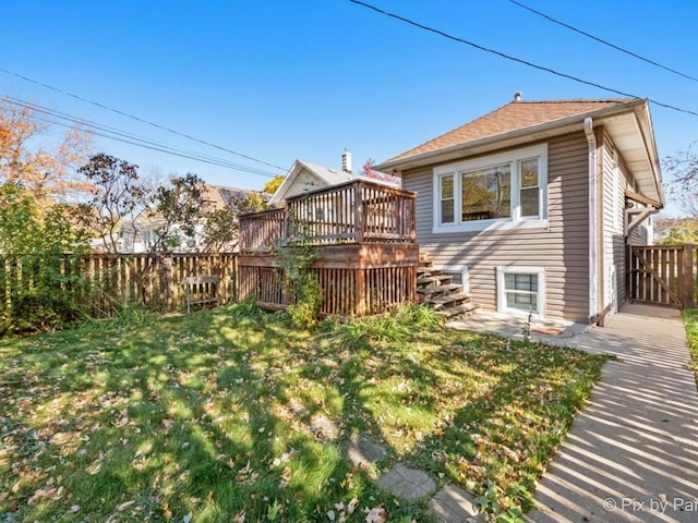 back of property featuring a lawn and a deck