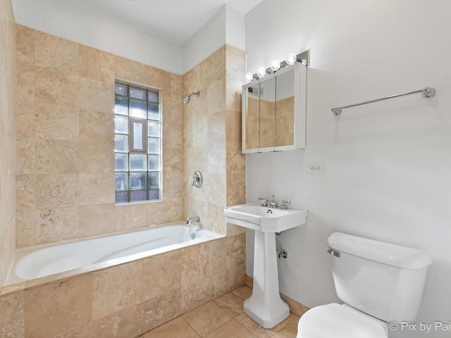 bathroom featuring tile patterned floors, tiled shower / bath, and toilet