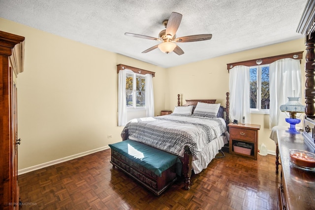 bedroom with dark parquet floors, ceiling fan, and a textured ceiling