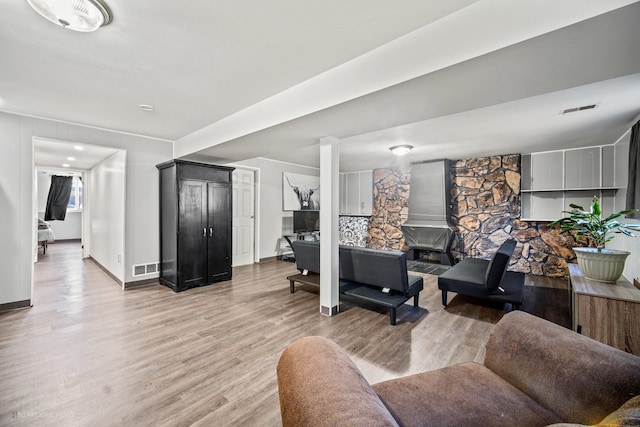 living room featuring a wood stove and light hardwood / wood-style floors