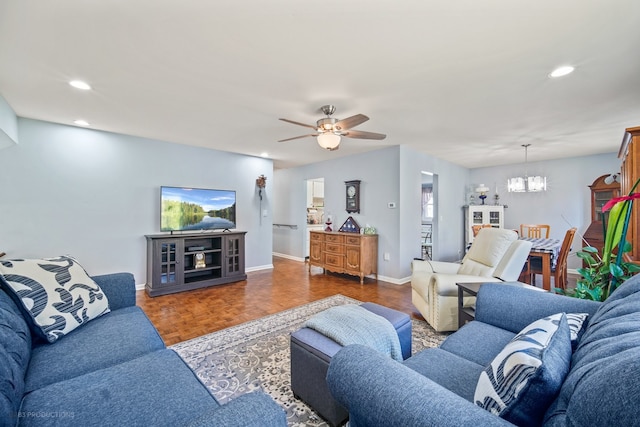 living room with ceiling fan with notable chandelier and dark parquet flooring