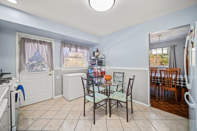 dining space featuring light tile patterned flooring and a notable chandelier