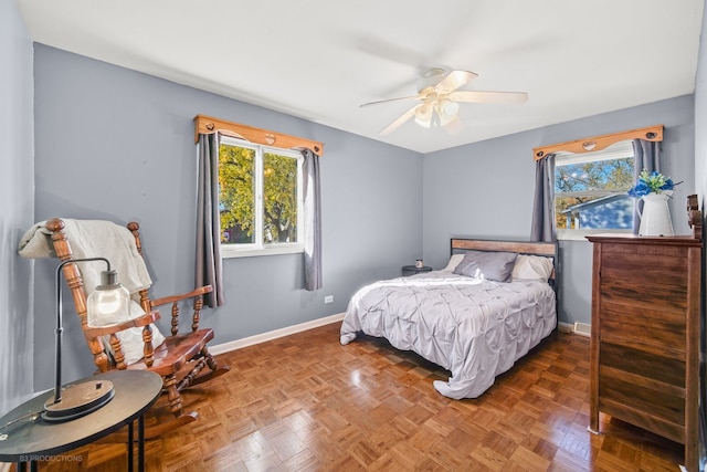 bedroom with ceiling fan and dark parquet flooring