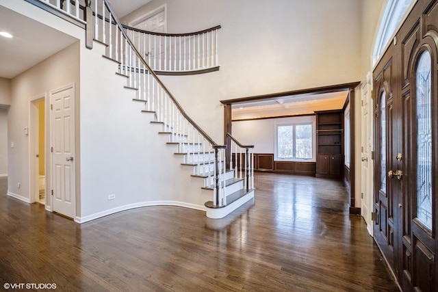 foyer entrance with a high ceiling and dark wood-type flooring