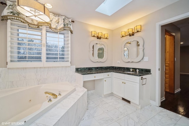 bathroom featuring vanity, tiled bath, and a skylight