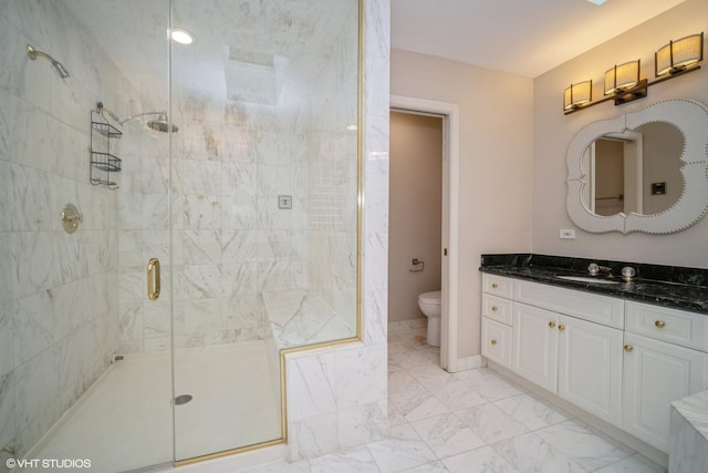 bathroom with vanity, a shower with shower door, and toilet