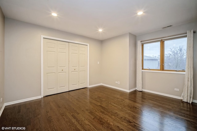 unfurnished bedroom featuring dark hardwood / wood-style floors and a closet