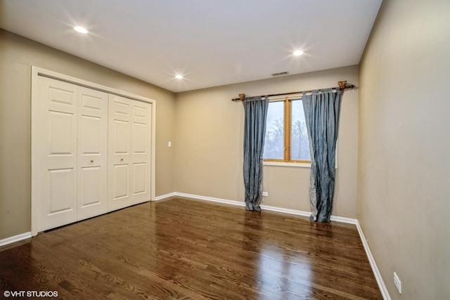 unfurnished bedroom featuring dark hardwood / wood-style flooring and a closet