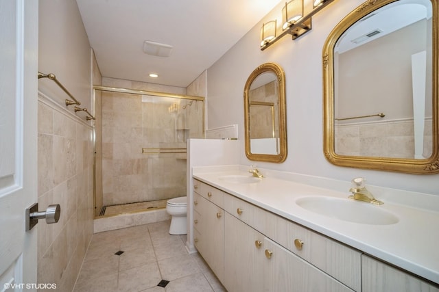 bathroom featuring vanity, toilet, an enclosed shower, and tile patterned flooring