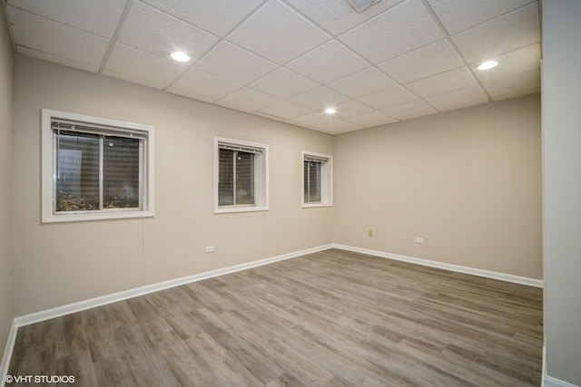 unfurnished room featuring hardwood / wood-style floors and a paneled ceiling