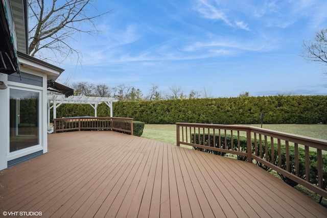 wooden deck featuring a lawn and a pergola