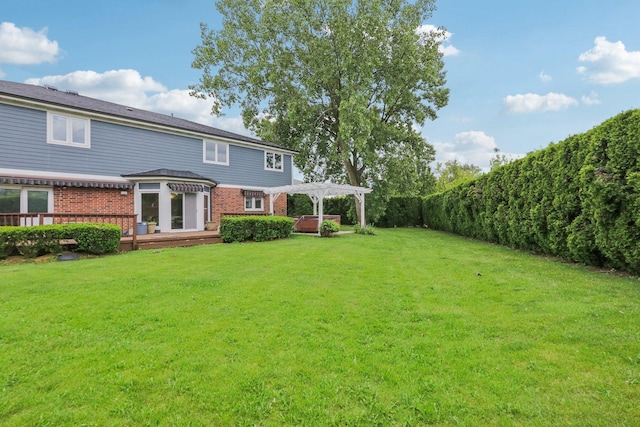 back of property with a hot tub, a lawn, a deck, and a pergola