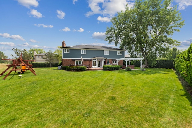 back of house featuring a pergola, a lawn, and a playground