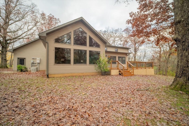 rear view of property featuring a wooden deck and a sunroom