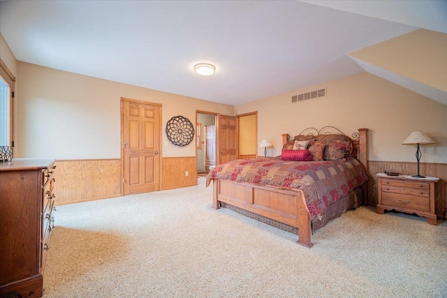 carpeted bedroom with wood walls and lofted ceiling