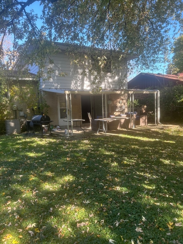 back of property featuring a patio and a lawn