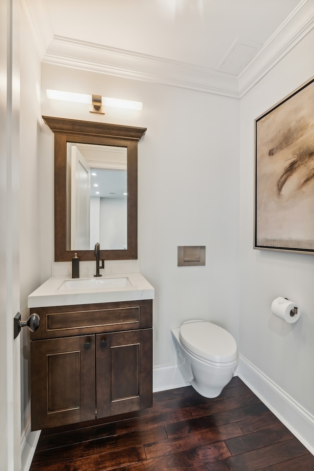 bathroom with vanity, crown molding, hardwood / wood-style flooring, and toilet