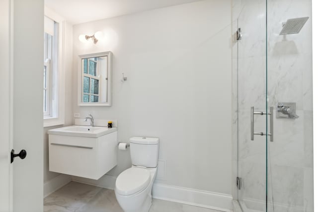 bathroom with vanity, toilet, and a shower with door