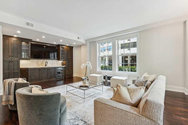 living room with sink, dark hardwood / wood-style floors, and beverage cooler