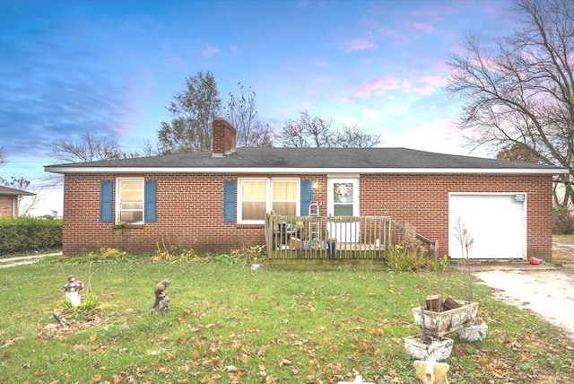 ranch-style house with concrete driveway, a front yard, a garage, brick siding, and a chimney