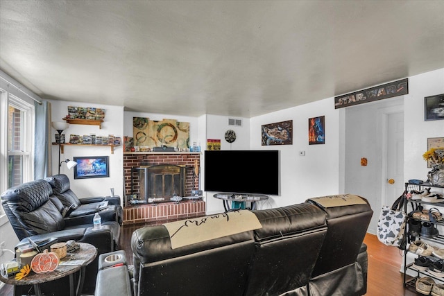 living room featuring visible vents, wood finished floors, and a fireplace