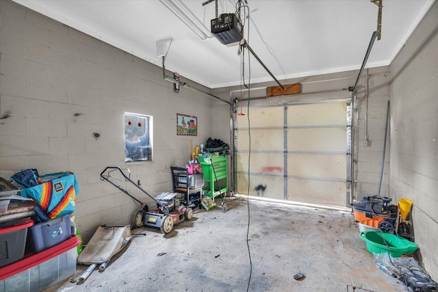 garage with a garage door opener and concrete block wall