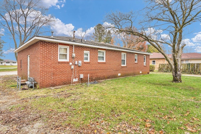 rear view of property featuring a yard and brick siding