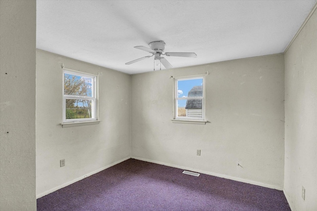 unfurnished room with visible vents, baseboards, carpet, and a ceiling fan