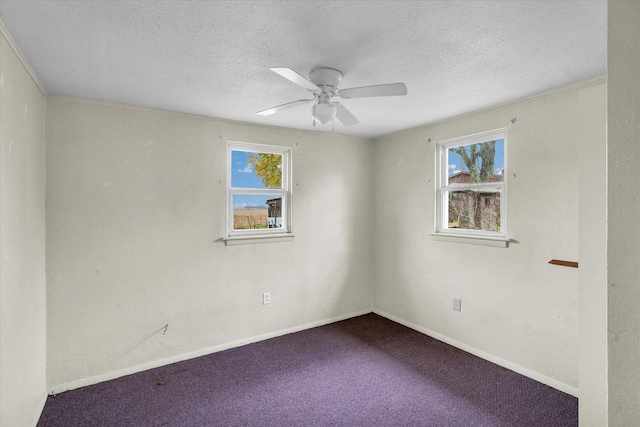 carpeted spare room featuring ceiling fan, baseboards, and a textured ceiling