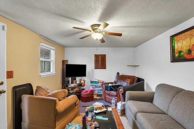 living area featuring a textured ceiling and a ceiling fan