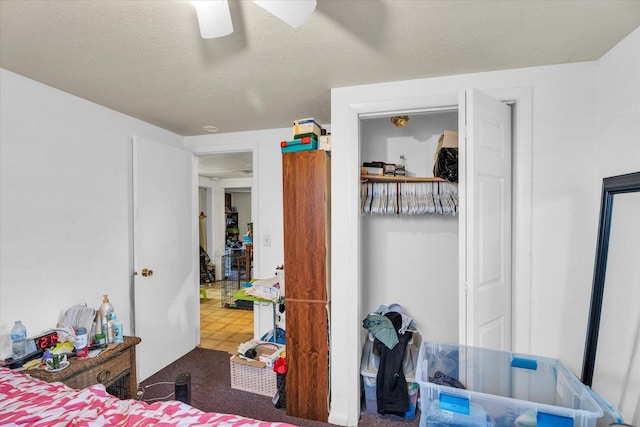 bedroom featuring tile patterned floors, a textured ceiling, and ceiling fan