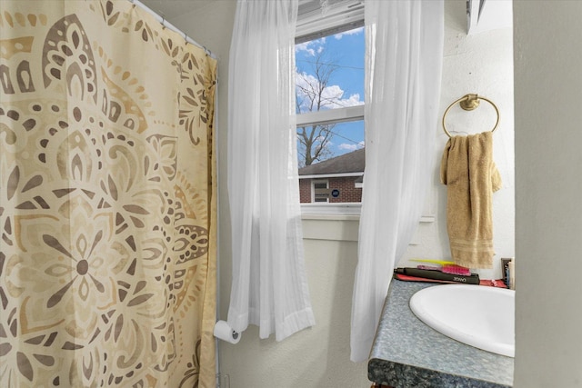 bathroom featuring vanity and a textured wall