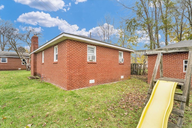 view of side of property with crawl space, a yard, a chimney, and brick siding