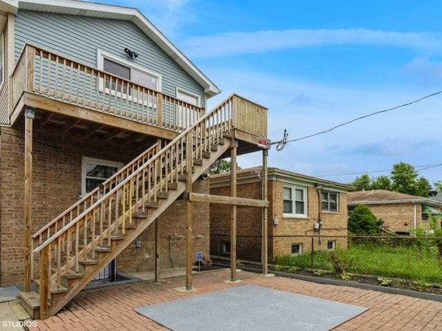 back of property with a wooden deck and a patio area