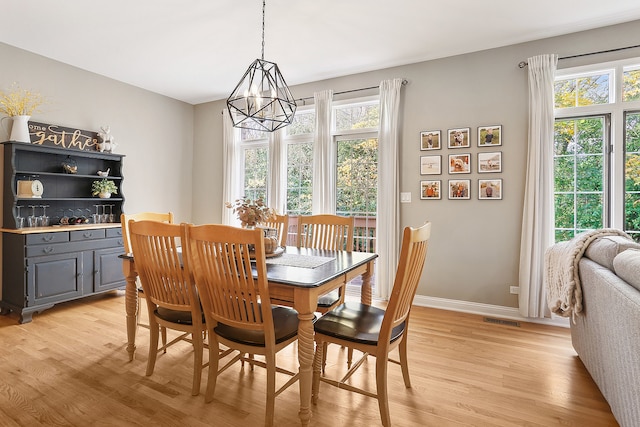 dining space featuring light hardwood / wood-style floors and an inviting chandelier