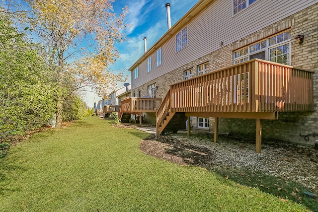 rear view of property with a deck and a lawn