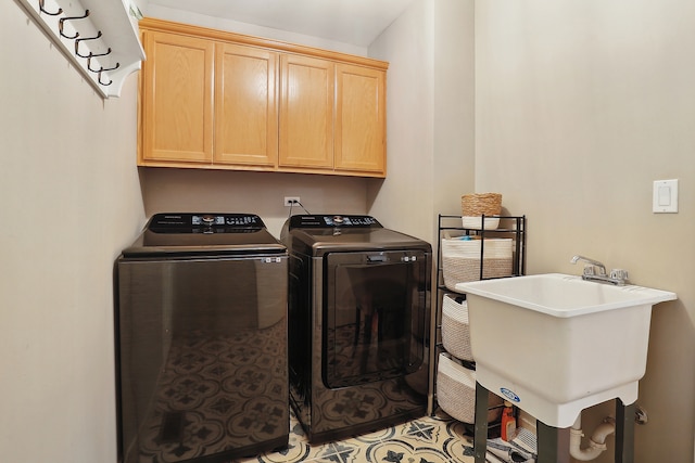 clothes washing area with cabinets, separate washer and dryer, and sink