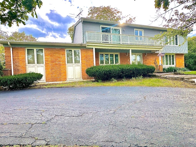 view of front property with a front yard and a balcony