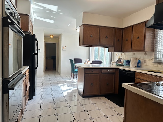 kitchen with tasteful backsplash, range hood, kitchen peninsula, dark brown cabinets, and black appliances