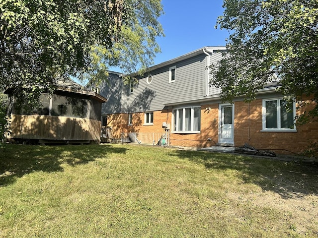 rear view of house featuring a yard