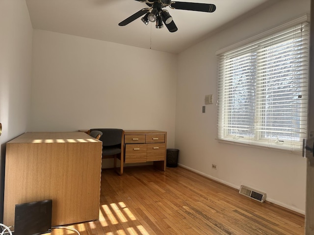 unfurnished office featuring light wood-type flooring and ceiling fan