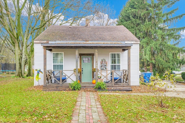 bungalow-style home featuring a front yard and a trampoline