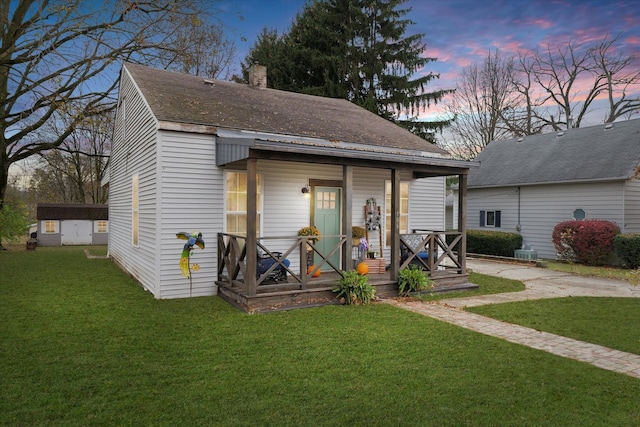 view of front of home featuring an outdoor structure and a lawn