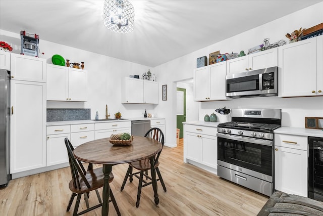 kitchen featuring light hardwood / wood-style floors, white cabinetry, sink, and appliances with stainless steel finishes