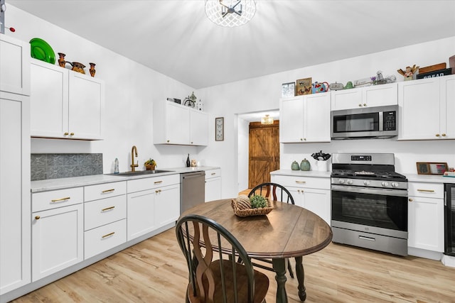 kitchen featuring light hardwood / wood-style floors, sink, white cabinetry, and stainless steel appliances