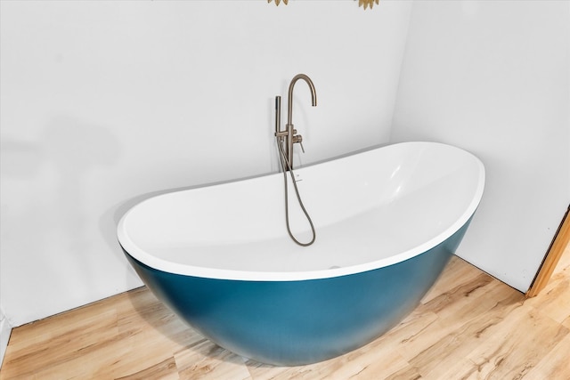 interior details with a washtub and hardwood / wood-style floors