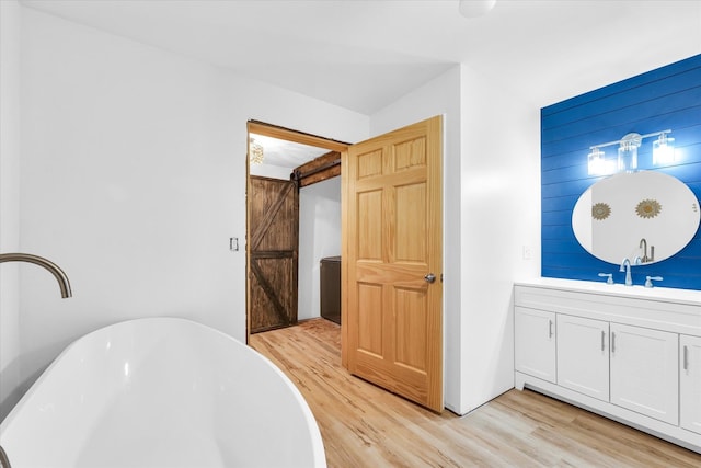 bathroom featuring a bathing tub, vanity, and hardwood / wood-style flooring