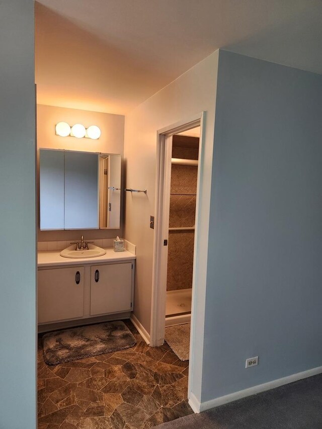 709 79th St Unit 309, Darien, IL 60561 - bathroom with vanity, baseboards, and a shower stall