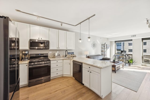 kitchen with white cabinetry, kitchen peninsula, sink, and appliances with stainless steel finishes