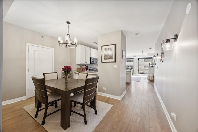 dining room featuring a notable chandelier and light wood-type flooring